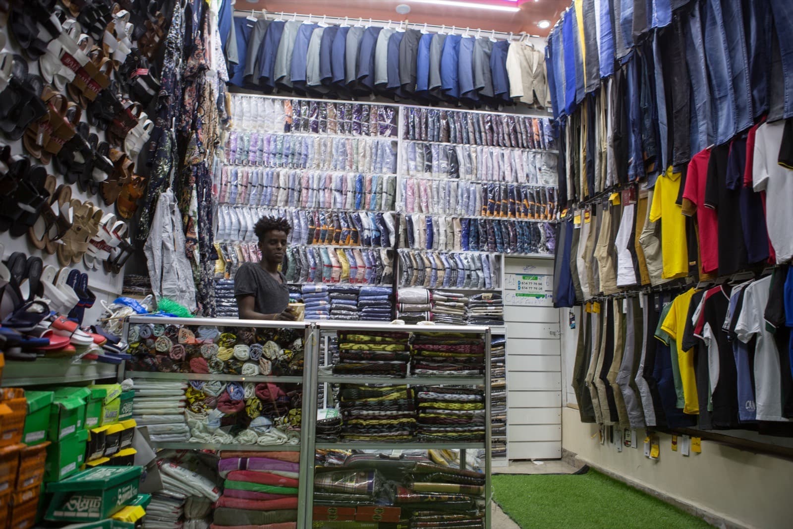 A busy African market shop with goods displayed for customers
